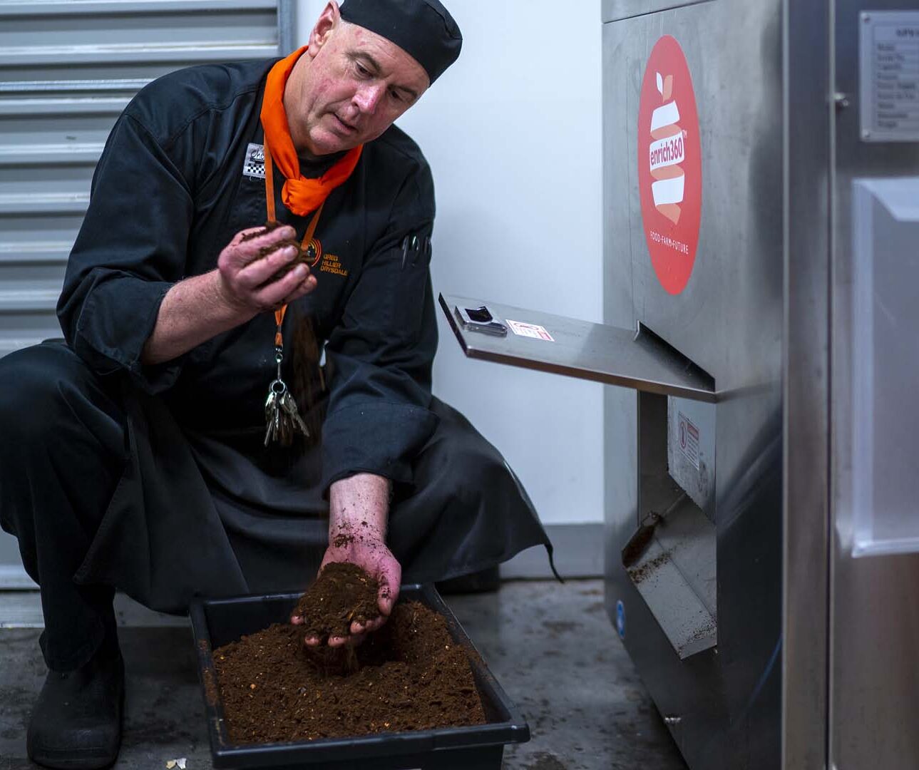 A chef inspecting compost made from restaurant food waste.