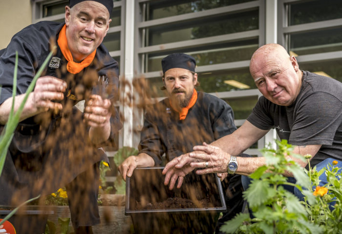 Image of staff at Drysdale North spreading compost on a kitchen garden